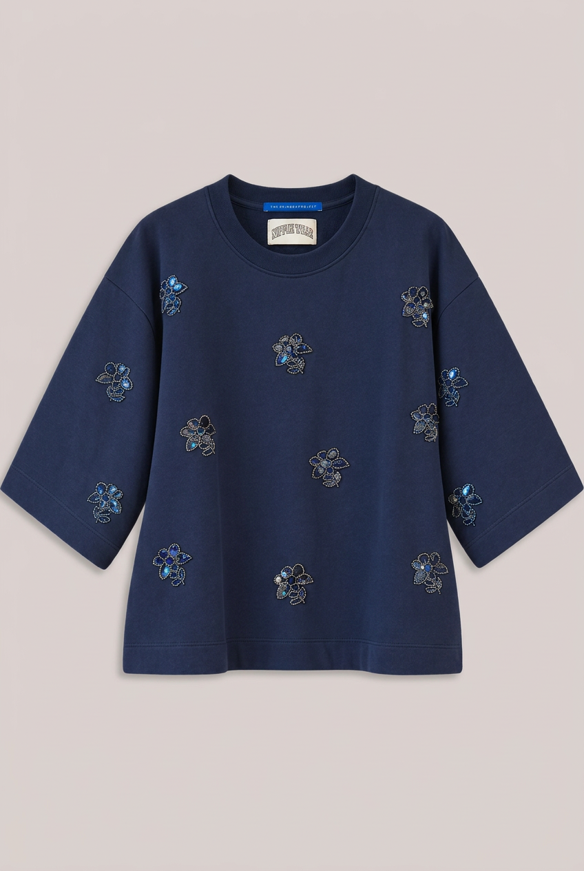 Dunkelblauer Pailletten-Sweater von TheShirtProjekt vor greigefarbenem Hintergrund