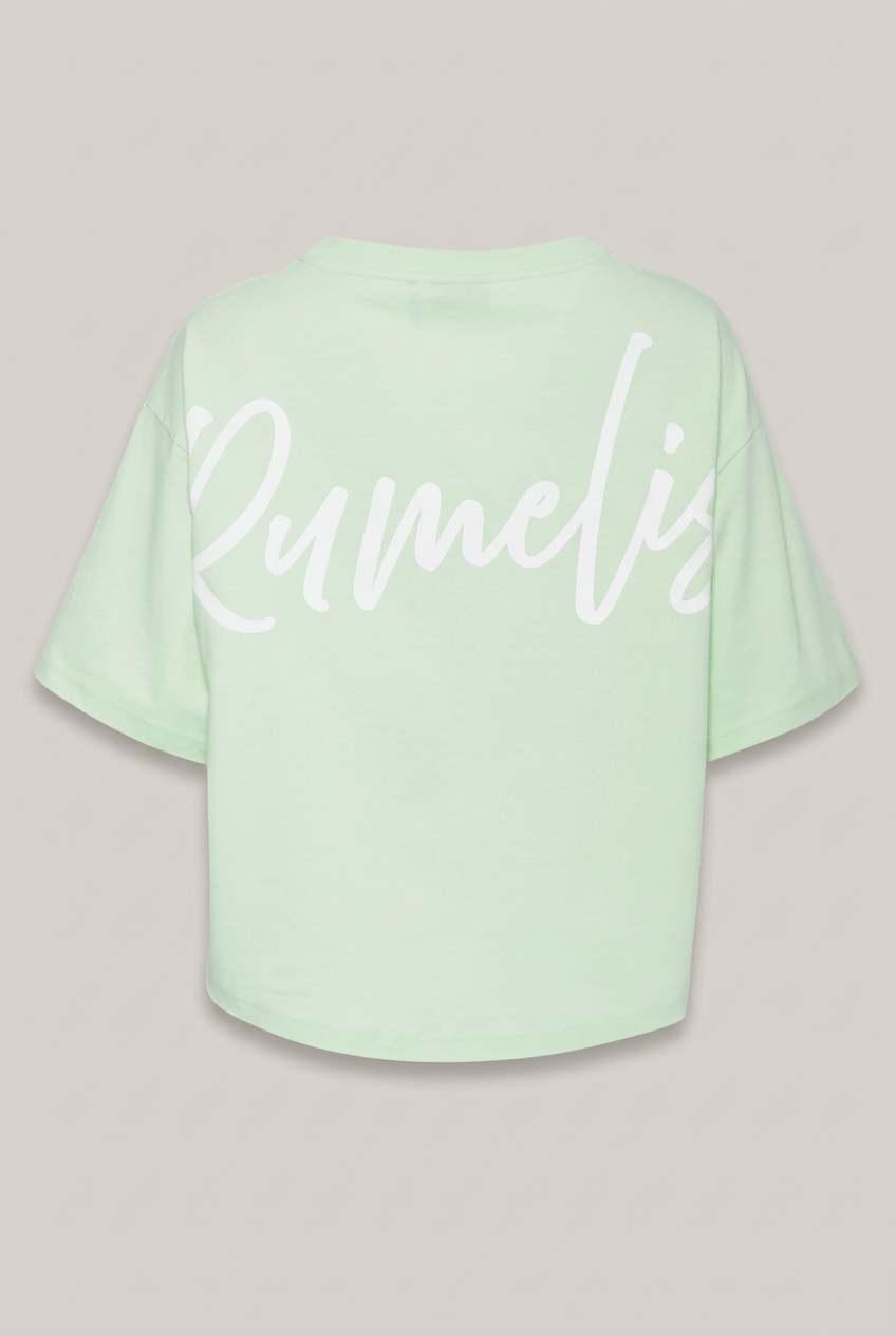 Elias Rumelis Patricia T-Shirt in Apple mit weißem Logo-Print, Rückansicht vor warmem Greige-Hintergrund