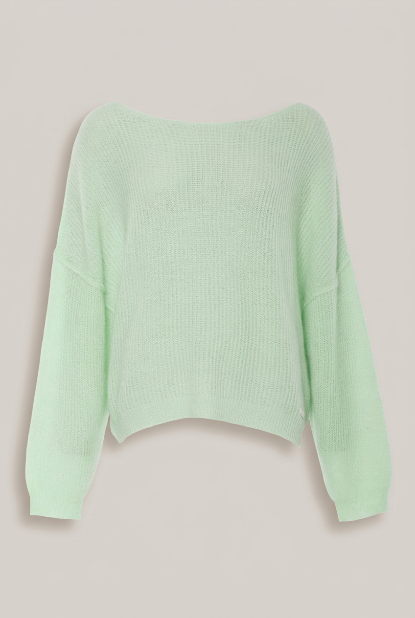 Elias Rumelis Lou Stricksweater in hellem Apfelgrün vor warmem Greige-Hintergrund