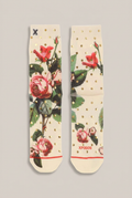 Cremefarbene XPOOS Socken mit Rosenmotiv und goldfarbenen Punkten vor Greige-Hintergrund