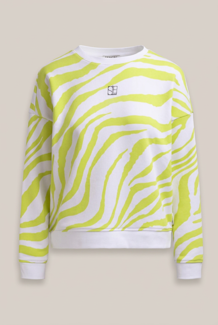 SENCES THE LABEL SURI Sweatshirt mit limettengelbem Zebramuster vor warmem Greige-Hintergrund