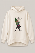 KERA TILL Hoodie mit Frau und Weihnachtsbaum vor hellem Greige-Hintergrund