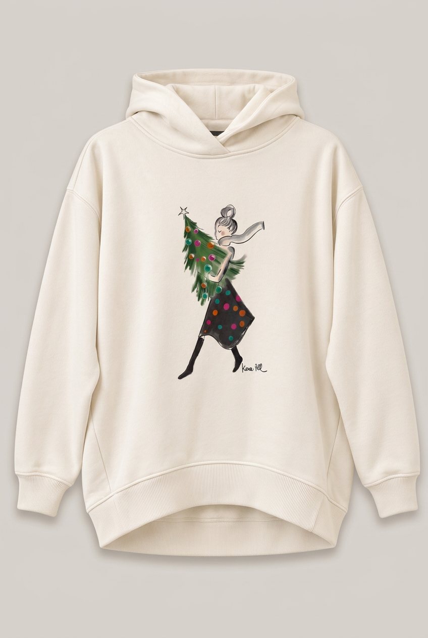KERA TILL Hoodie mit Frau und Weihnachtsbaum vor hellem Greige-Hintergrund