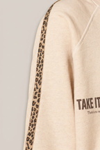 GRACE Sweatshirt Ärmeldetail mit Leo-Besatz vor Greige-Hintergrund