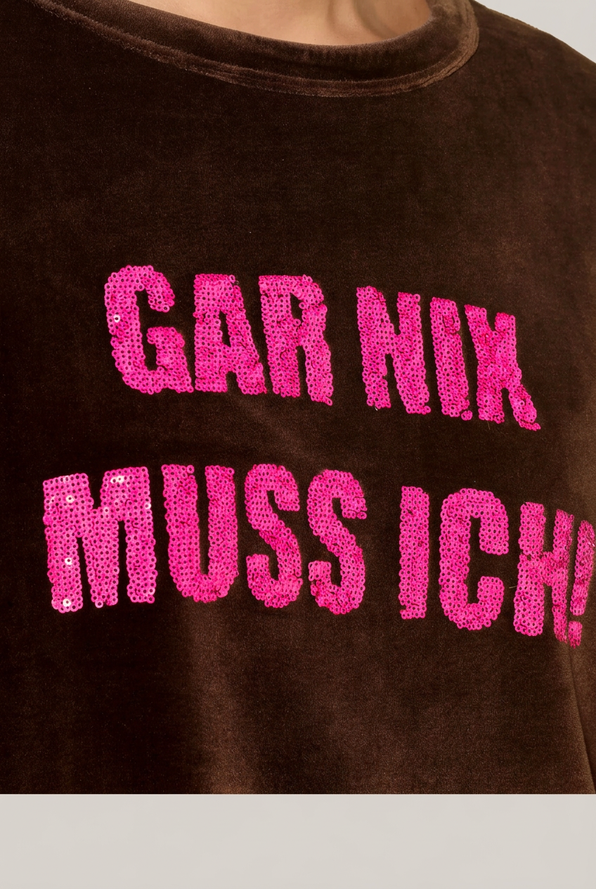 Detail des intensiv pinken Pailletten-Schriftzugs GAR NIX MUSS ICH auf dem moccabraunen GRACE Langarmshirt