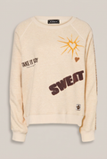 GRACE Sweatshirt in Creme mit Motiven vor warmem Greige-Hintergrund