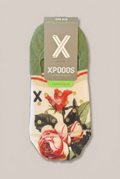 XPOOS Footies mit Blumenmotiv und goldfarbenen Punkten in Originalverpackung vor warmem Greige-Hintergrund