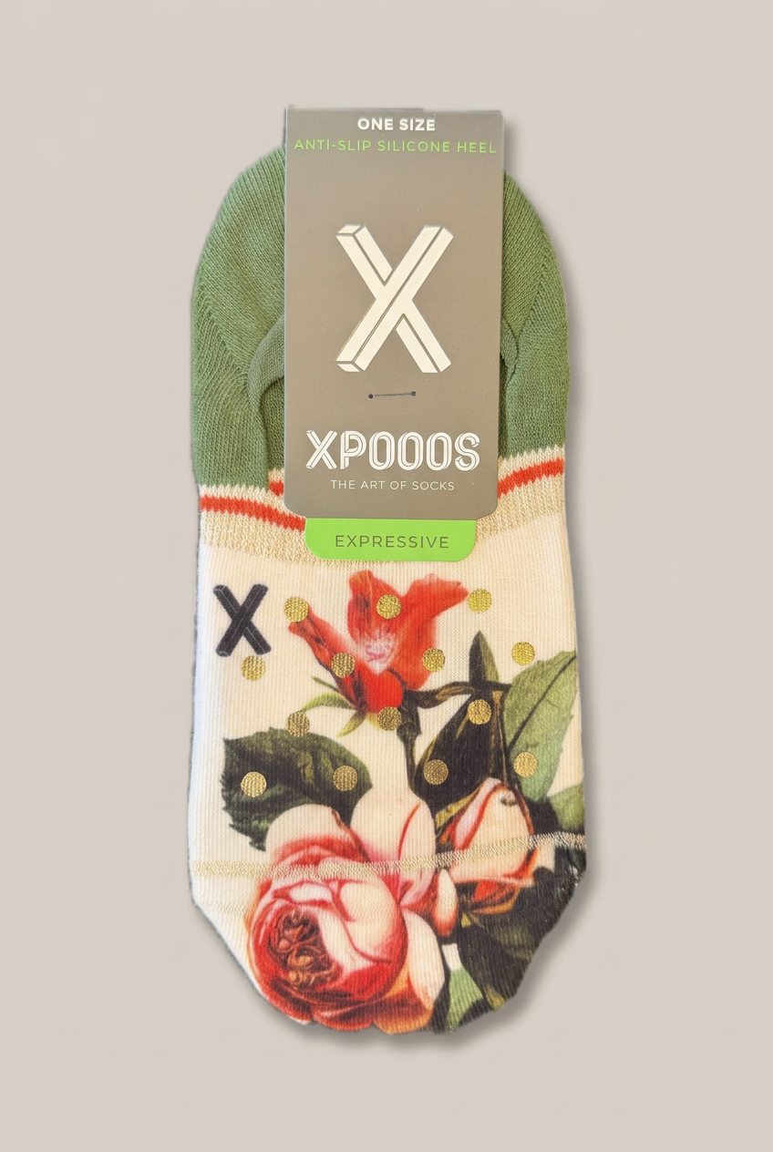 XPOOS Footies mit Blumenmotiv und goldfarbenen Punkten in Originalverpackung vor warmem Greige-Hintergrund